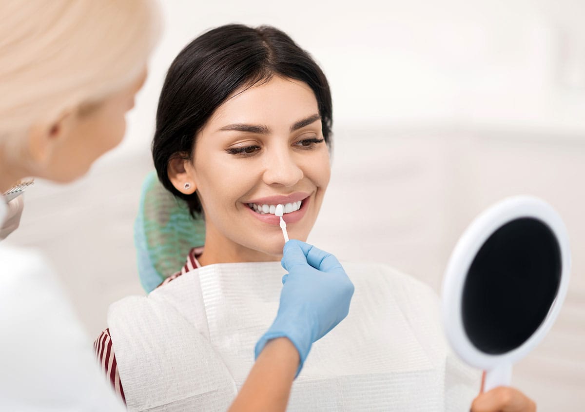 A woman is trying porcelain veneers at dental