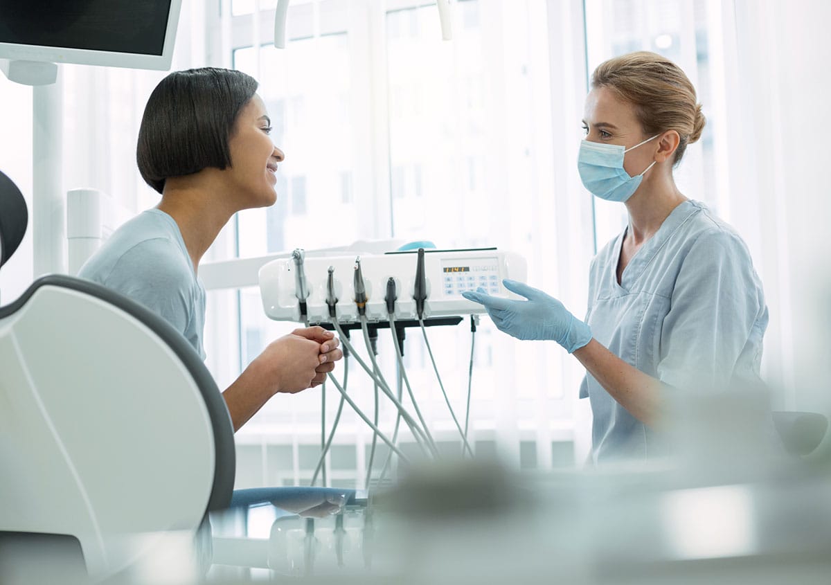 A woman is talking to a dentist