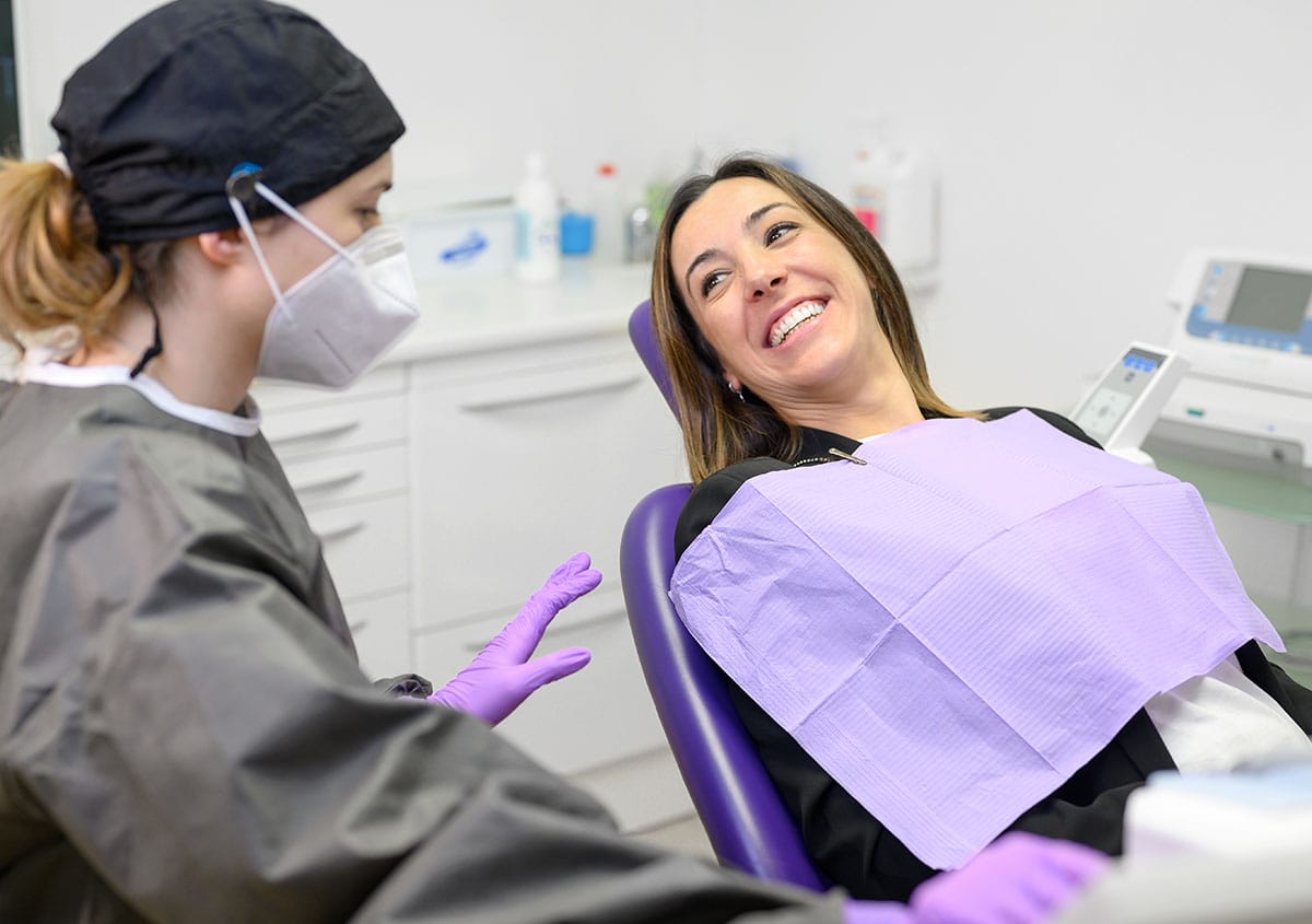 A woman is talking to the dentist