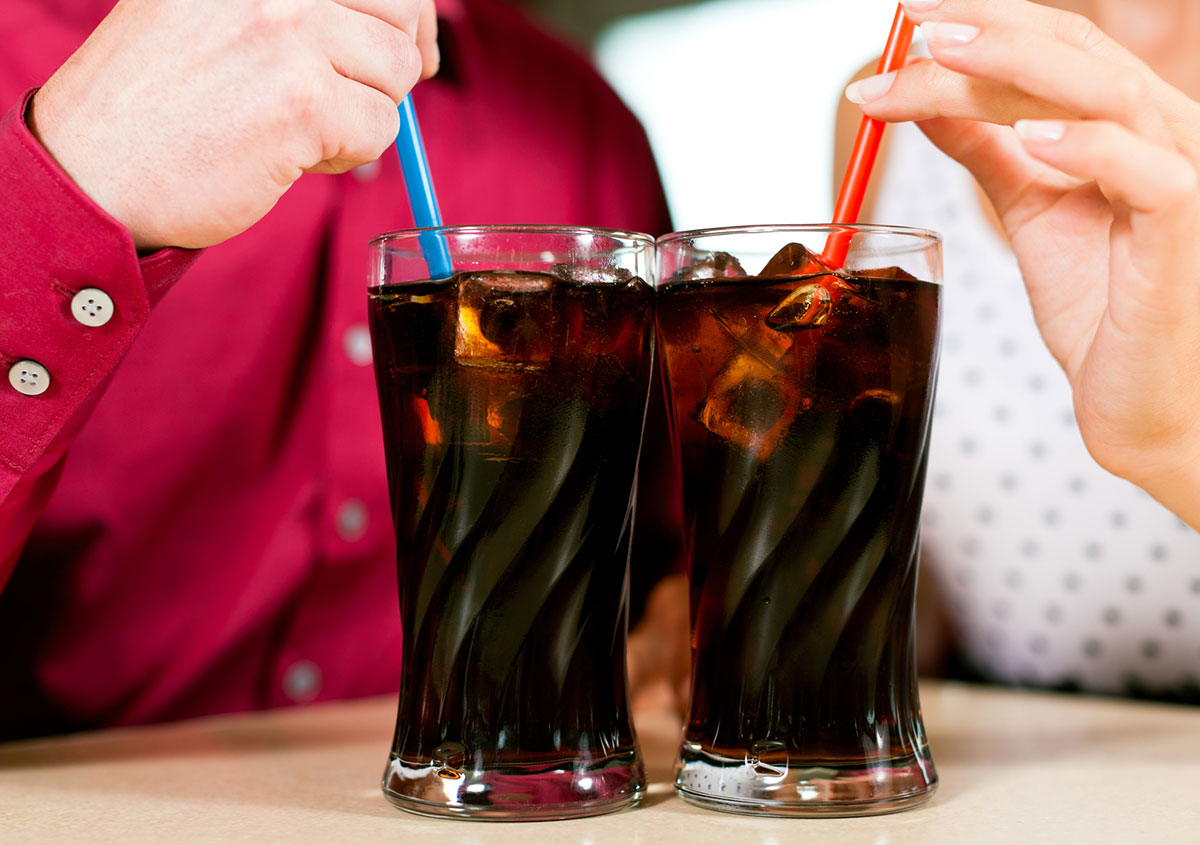 A couple is drinking soda in a restaurant